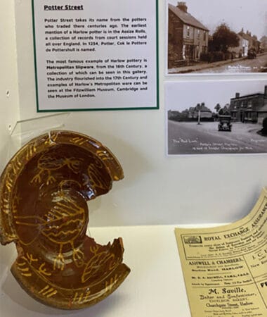 A photograph of a cabinet display from the pottery and Harlow history exhibit at the Parish Gallery in Harlow museum.in Harlow Museum